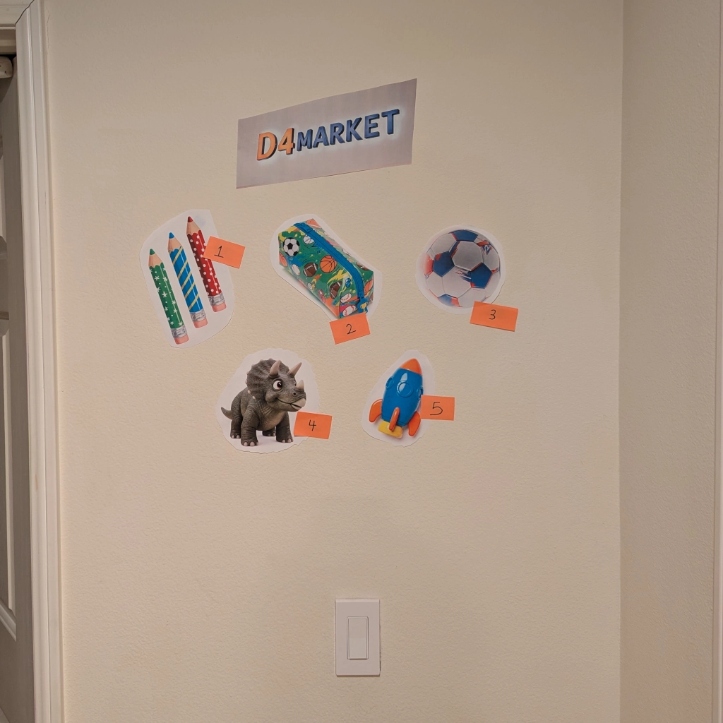 Makeshift market display—Cutouts of toy pictures stuck on a wall and labeled with prices